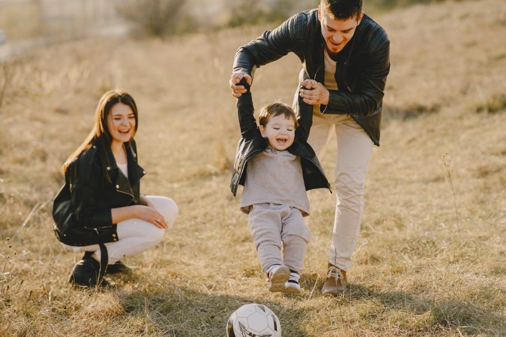 parents qui jouent avec leur enfant au football